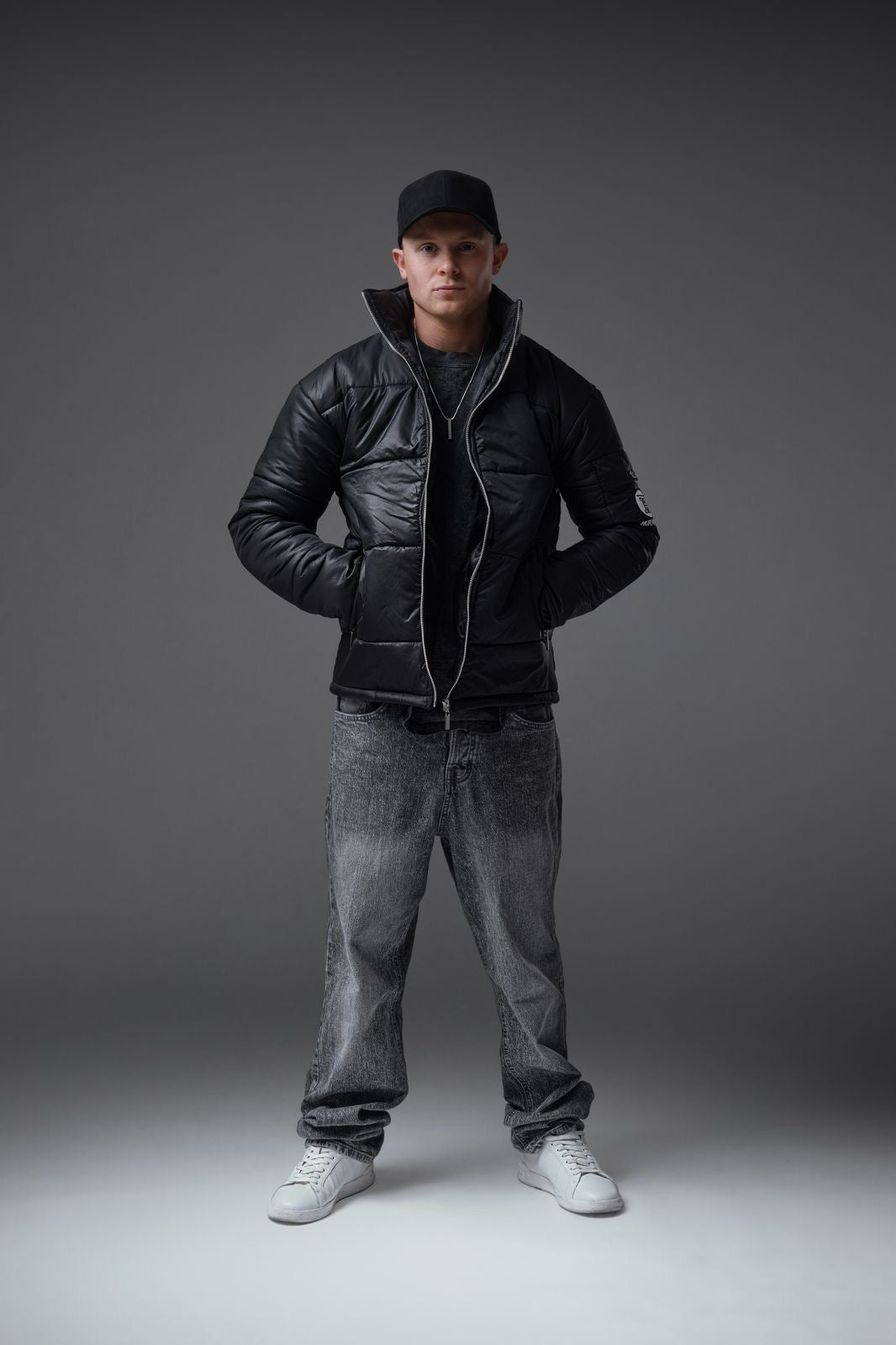 The Signature Huracan Men &amp; Women's Black Puffer Jacket standing front pockets long shot