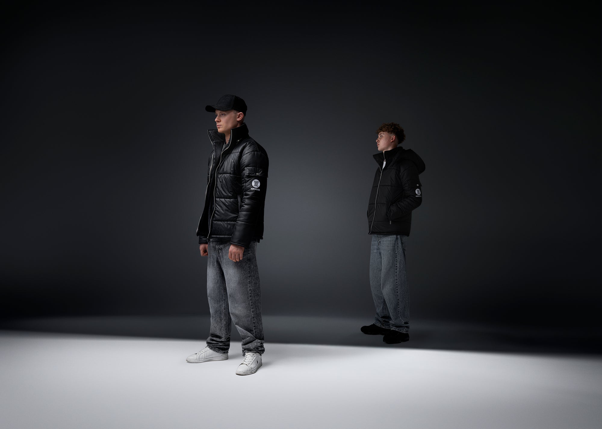 The Signature Huracan Men &amp; Women's Black Puffer Jacket hooded standing front side angled mantle double model