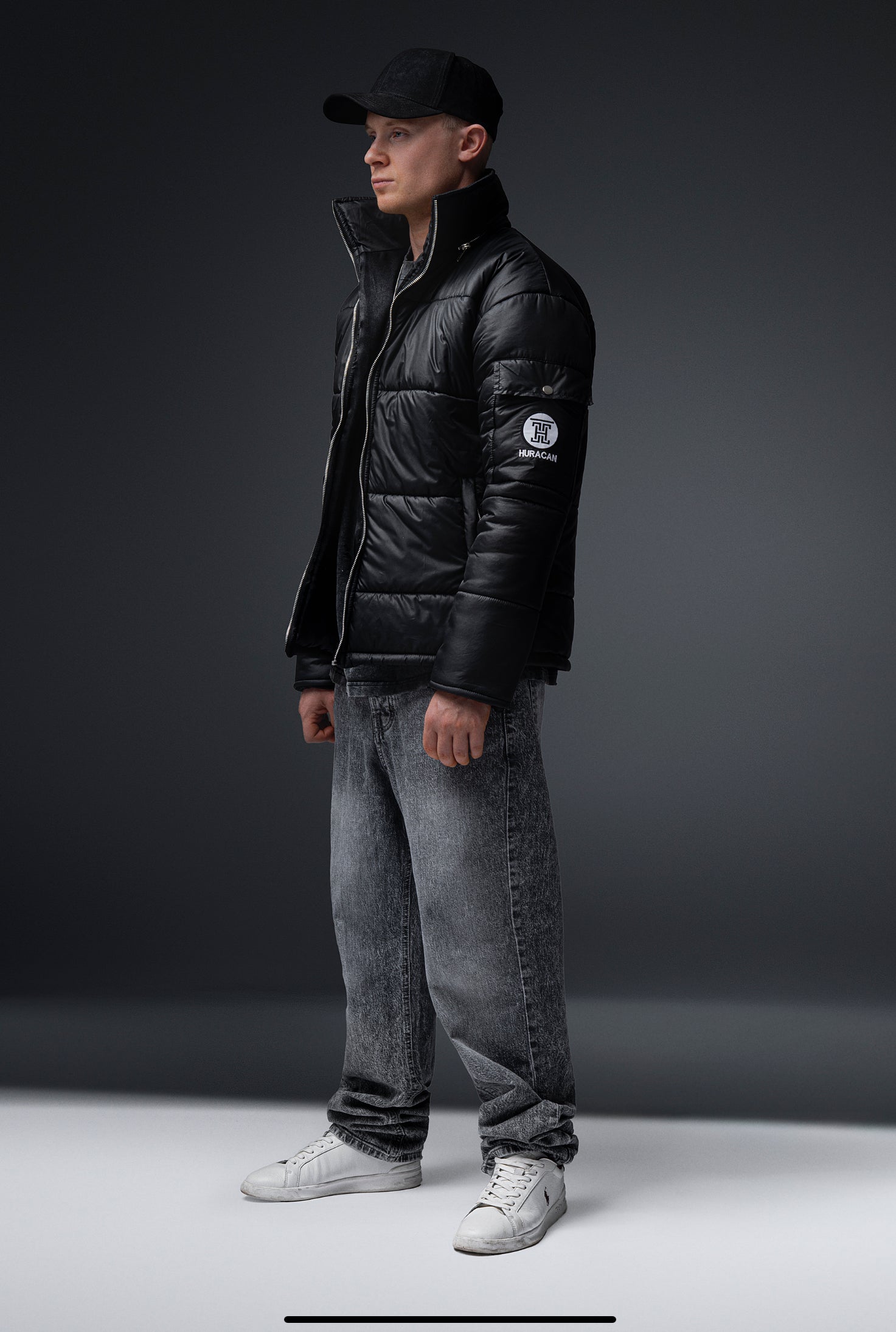 The Signature Huracan Men &amp; Women's Black Puffer Jacket standing side angle long shot