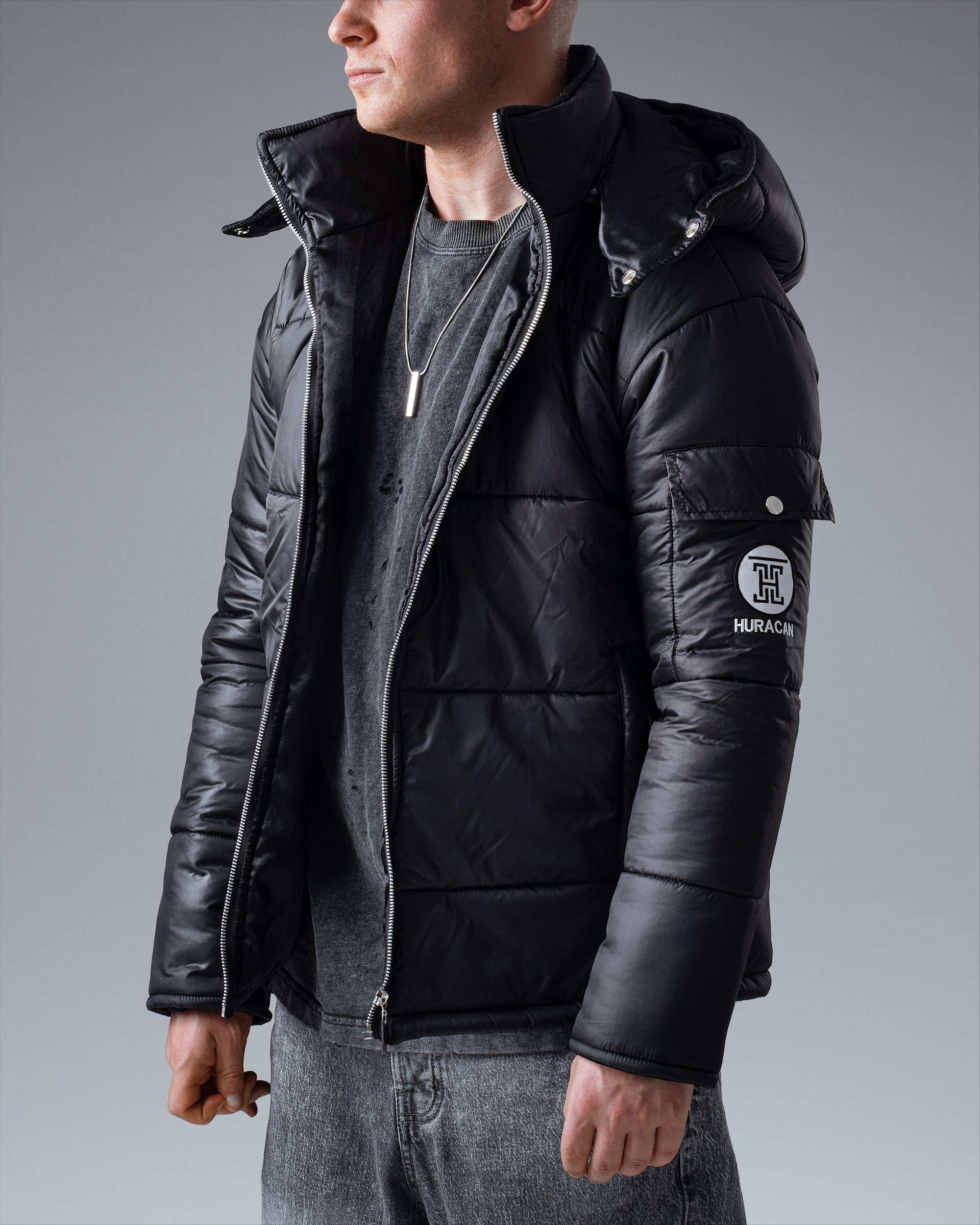 The Signature Huracan Men &amp; Women's Black Puffer Jacket hooded standing side angle