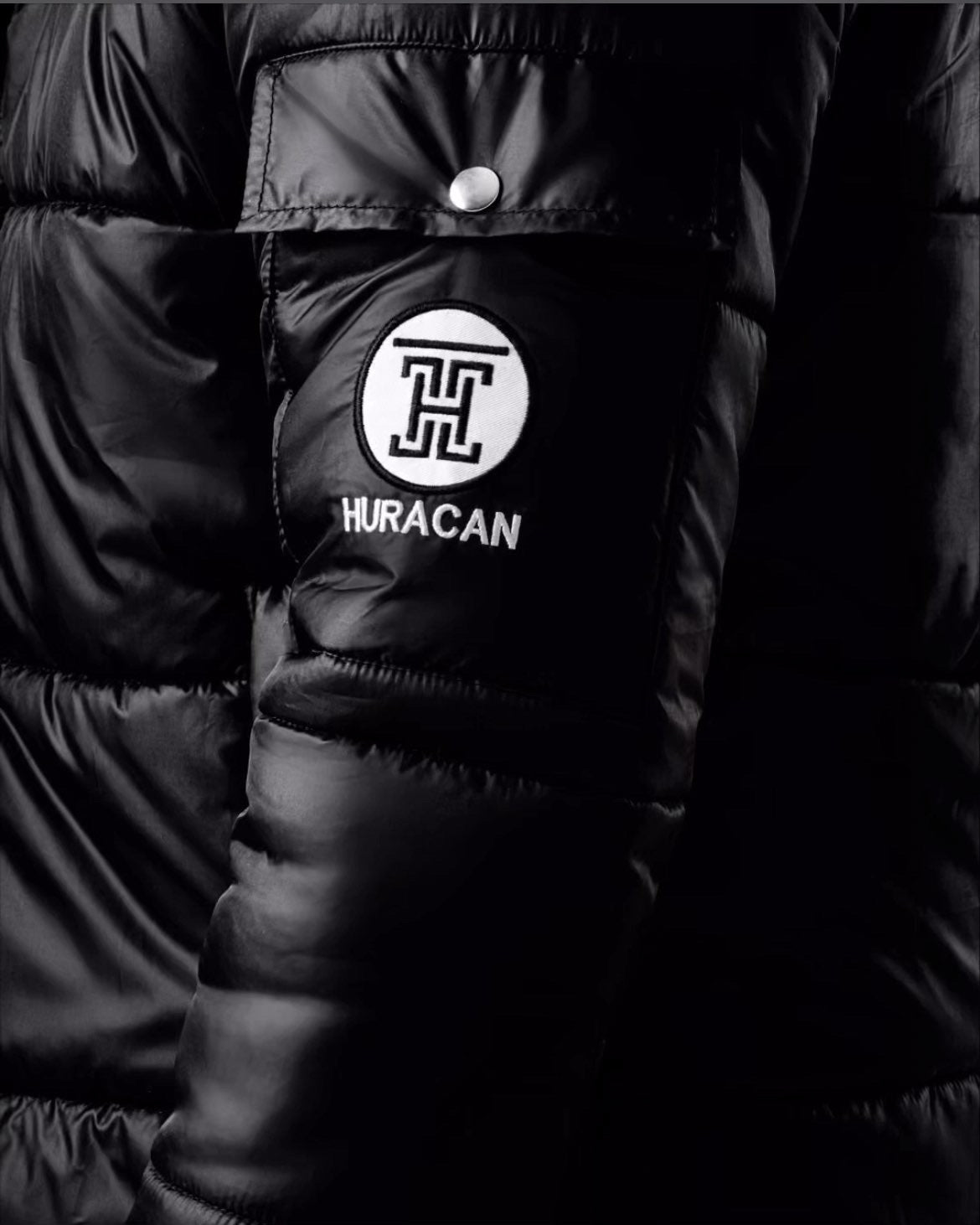 The Signature Huracan Men &amp; Women's Black Puffer Jacket side arm close up