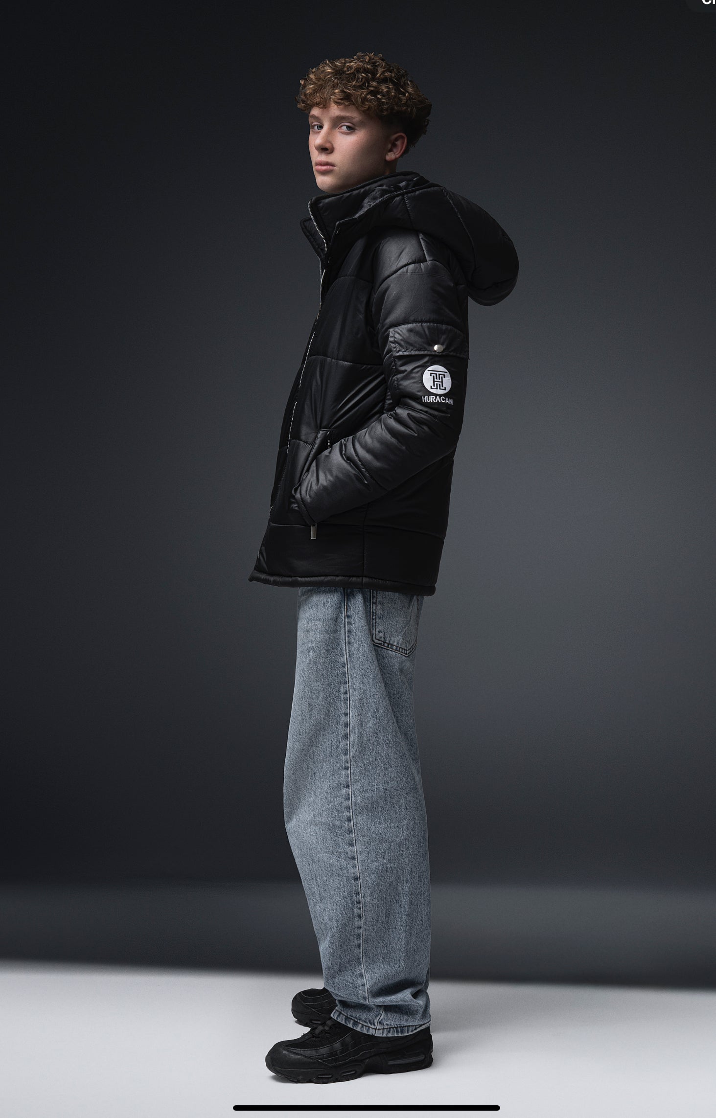 The Signature Huracan Men &amp; Women's Black Puffer Jacket hooded standing side black background